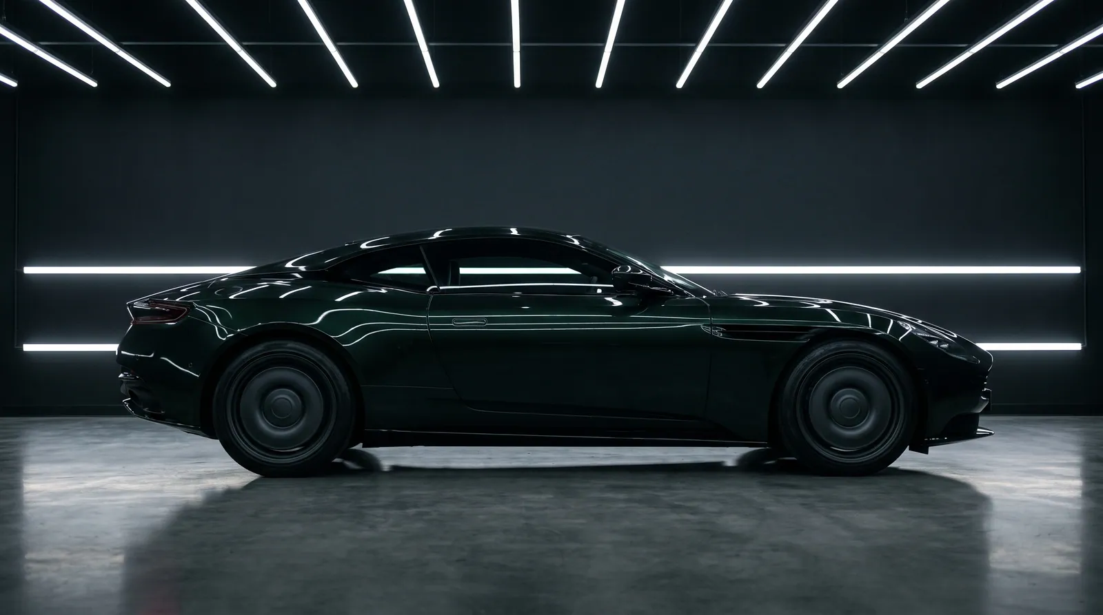 A deep green coupé in a dark studio, ceiling light tubes reflected along its side.
